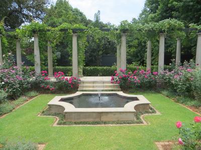 Raised Pergola Behind Pond And Rose Garden