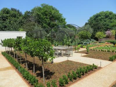Seating In A Veggie Garden Under A Grapevine Pergola